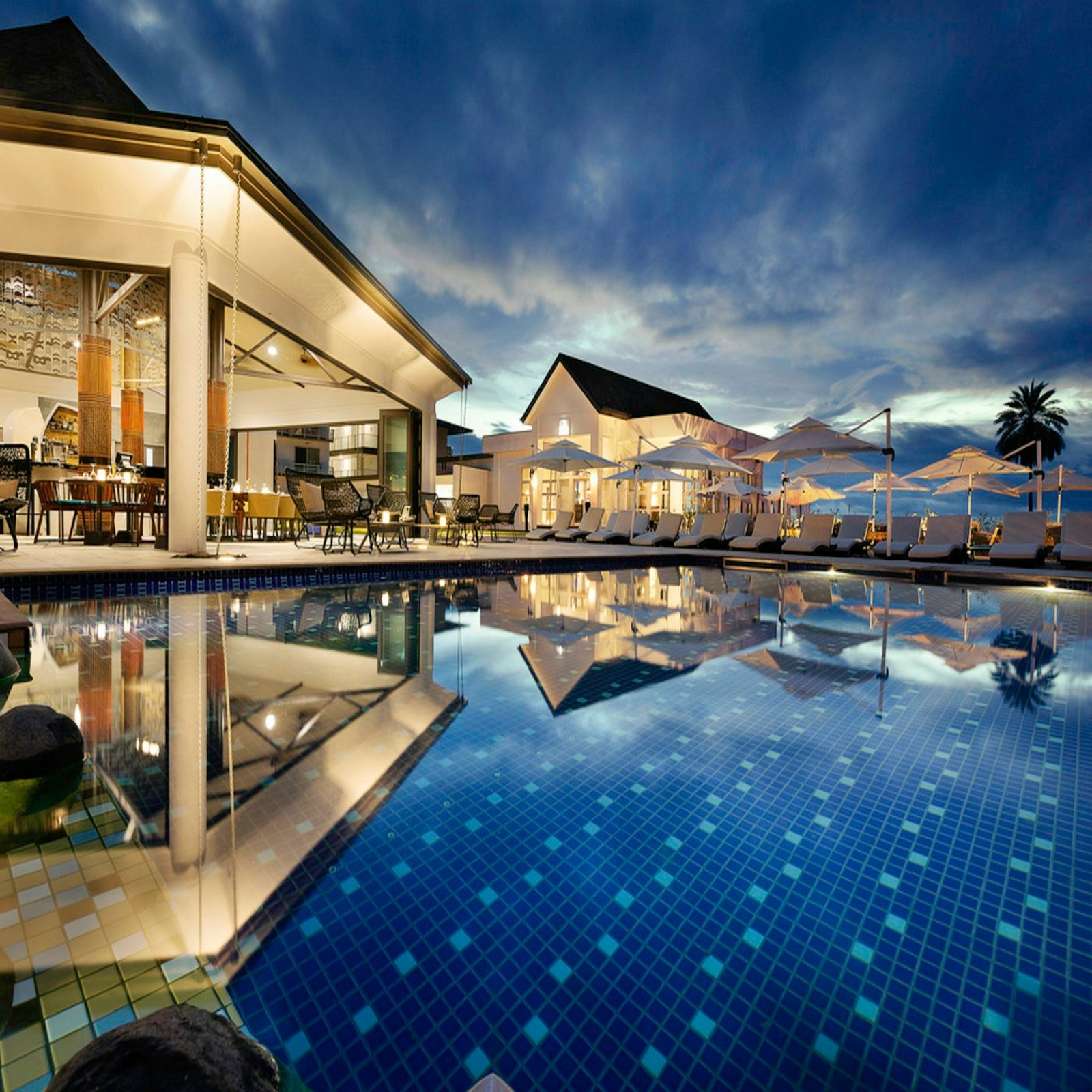 Night view of illuminated modern residences and pool at Capella Nuova
